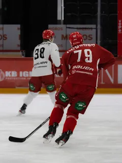 Kaksi miestä pelaamassa jääkiekkoa pelissä