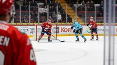 Jääkiekko-ottelu Helsingin jäähallissa, pelaajat taistelevat kiekosta kaukalossa.