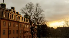 Korkea rakennus, jossa kello huipulla, pilvistä taivasta vasten