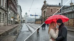 Pariskunta punaisen sateenvarjon alla Helsingissä sateisella kadulla