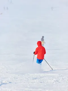 Hiihtäjä rinteessä lumisella rinteellä